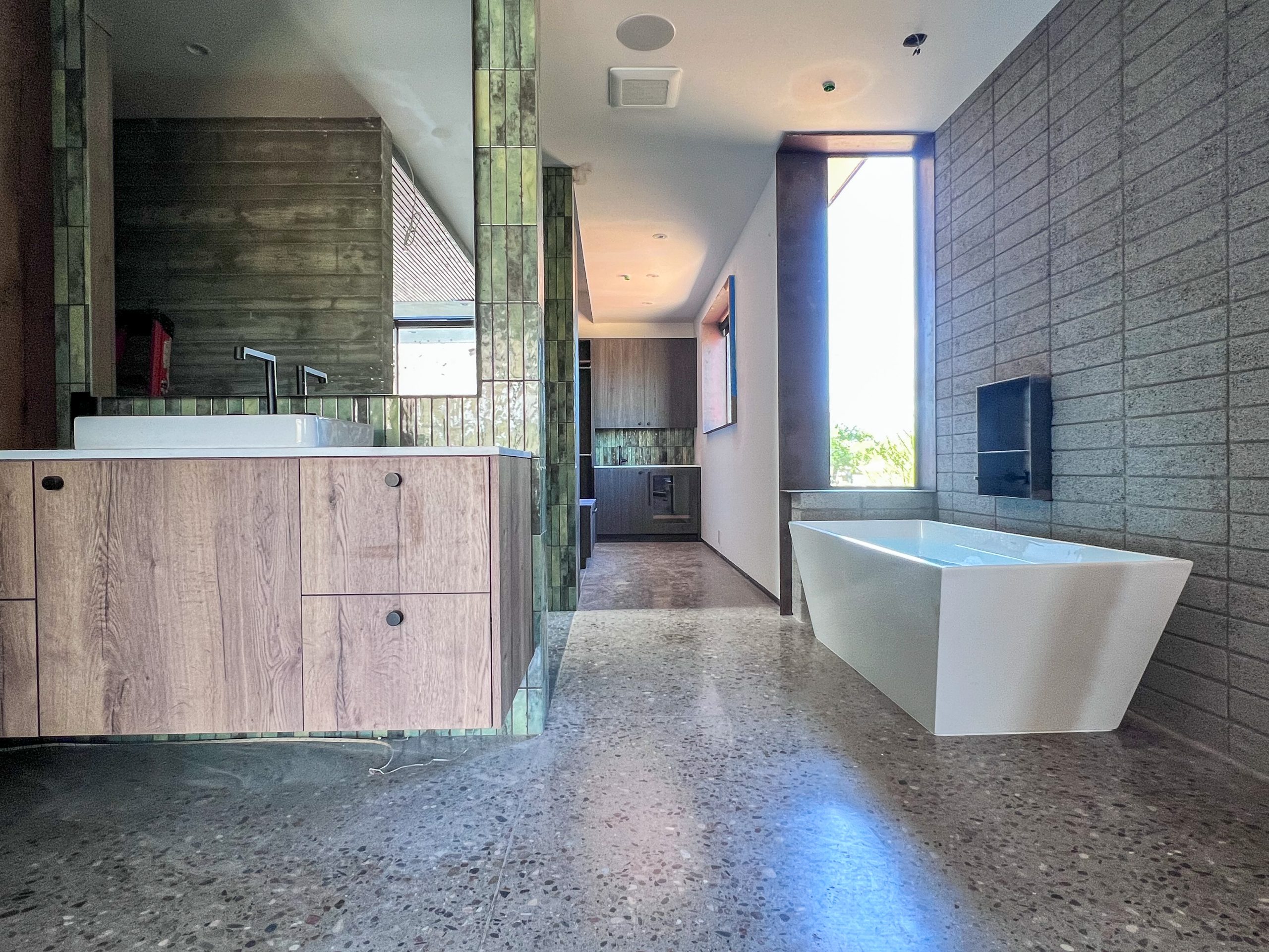 Modern primary bathroom with floating vanity and soaking tub